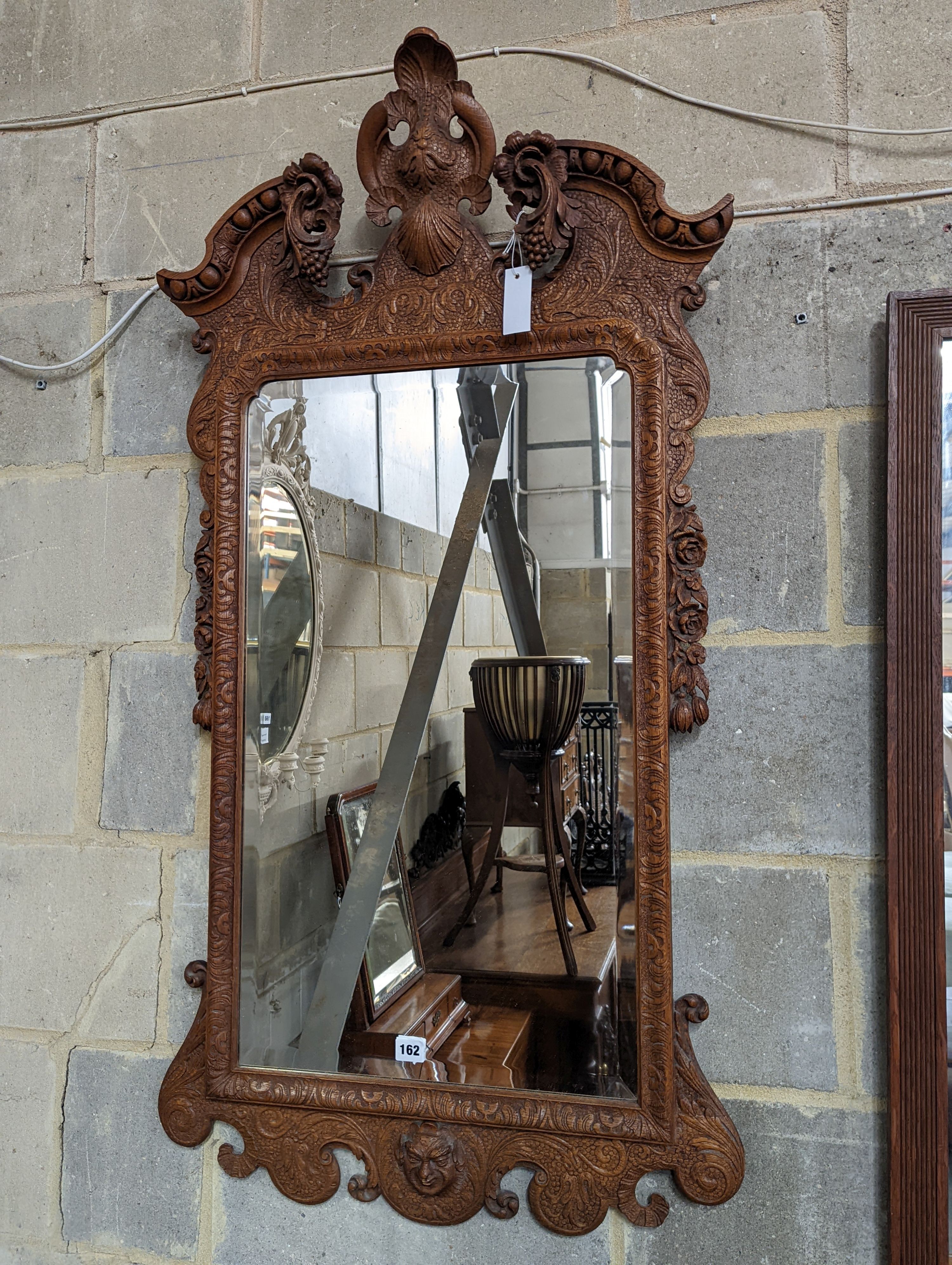 An 18th century style carved wood wall mirror, width 64cm, height 124cm